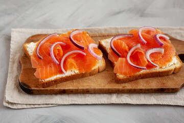 Homemade Smoked Salmon Toast on a rustic wooden board, side view.