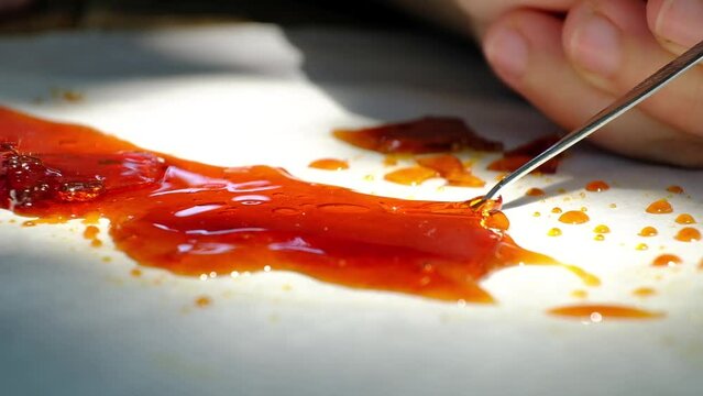 dab stick and high thc resin, orange cannabis concentrate wax closeup High quality FullHD footage