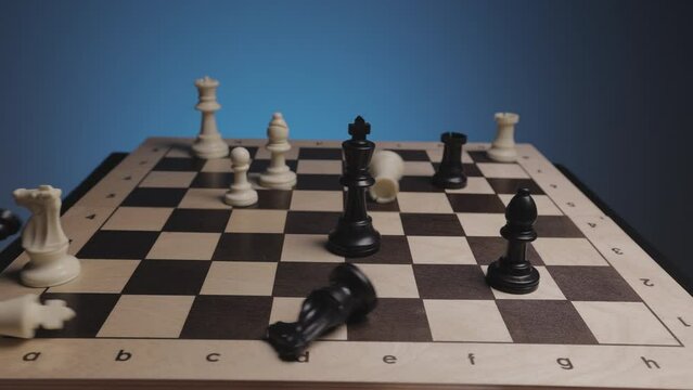 Chess in slowmo falls off the board. The camera is fixed on a chessboard.