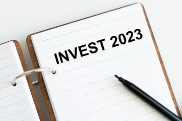 INVEST 2023 words on a sheet of open notepad on the table