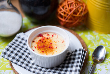 Panna cotta in a ceramic ramekin sprinkled with dried raspberry crumbs