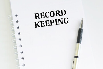 RECORD KEEPING text written on a notebook on the white background