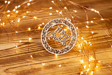  Christmas card. A wooden plate with Merry Christmas lettering and yellow Christmas lights on...