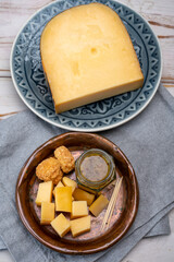 Cheese tasting, small pieces of old Dutch hard cheese and bowl with homemade dill-mustard sauce