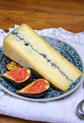 French semi-soft cow milk cheese morbier from Franche-Comte region with thin black layer and strong aroma close up