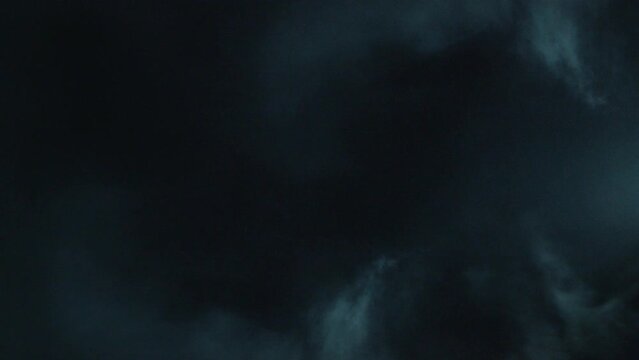 Spooky magic VFX Halloween.  Atmospheric smoke VFX element in 4k Slow-motion. Haze background. Dust, smoke cloud. Smoke on black background. White smoke crawls and floats through space on black bg. 