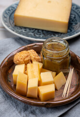 Cheese tasting, small pieces of old Dutch hard cheese and bowl with homemade dill-mustard sauce
