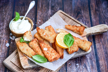   Allasca Pollock Fish  Bites in a crispy Tempura  Batter.Fish and chips .Close up of   crispy breaded  deep fried fish fingers with breadcrumbs s erved with remoulade sauce and  lemon