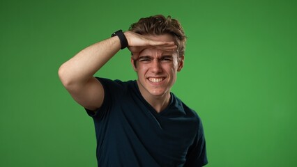 Portrait of happy smiling young man 20s smiling and look around for friend find waving meet greet with hand notices someone isolated on green screen background slow motion