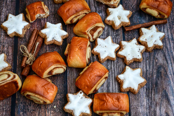  Freshly baked cinnamon buns with spices and cocoa filling on parchment paper. Top view. Sweet Homemade Pastry christmas baking. Close-up. Kanelbule - swedish dessert.and star shaped Christmas cookies