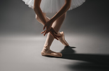 Close-up of ballet dancer's legs in pointe shoes and hands