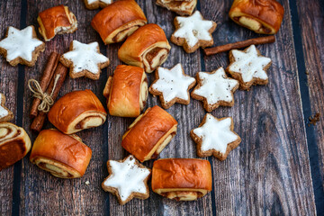  Freshly baked cinnamon buns with spices and cocoa filling on parchment paper. Top view. Sweet Homemade Pastry christmas baking. Close-up. Kanelbule - swedish dessert.and star shaped Christmas cookies