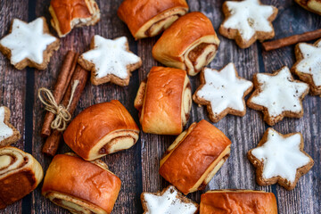  Freshly baked cinnamon buns with spices and cocoa filling on parchment paper. Top view. Sweet Homemade Pastry christmas baking. Close-up. Kanelbule - swedish dessert.and star shaped Christmas cookies