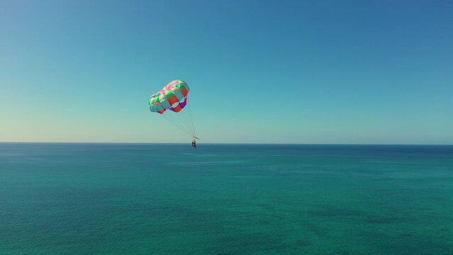Aerial view of Parasailing, also known as parascending, paraskiing or parakiting. West Caribbean coast in Jamaica, Negril. Parachuting man in the air. parachute over the Seven Mile Beach.