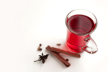 a glass cup of a red warming drink (tea, mulled wine, punch). ingredients for winter hot drinks.