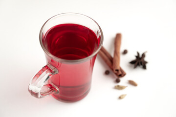 a glass cup of a red warming drink (tea, mulled wine, punch). ingredients for winter hot drinks.