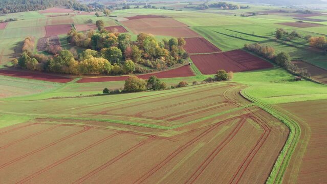 a lush farming landscape with a tractor from above 4k 30fps video