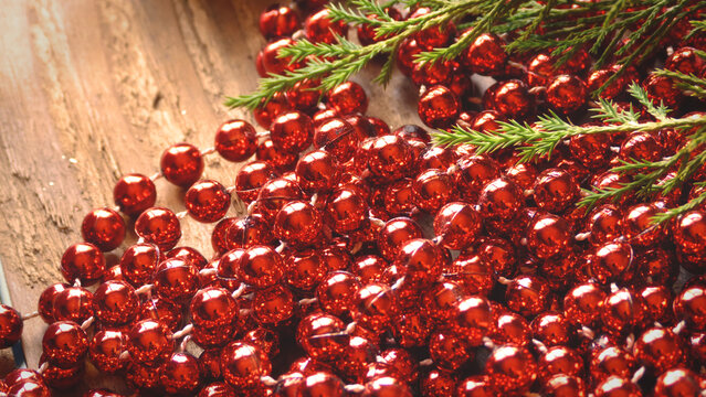 Close Up of Red Beads with Evergreen on a Wooden Background | Red Christmas Beads | Rustic Christmas