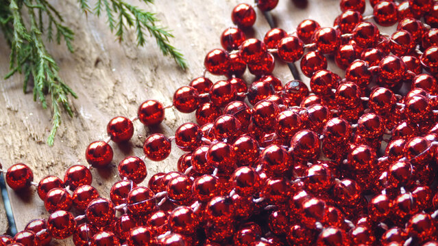 Close Up of Red Beads with Evergreen on a Wooden Background | Red Christmas Beads | Rustic Christmas