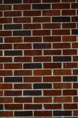 newly built red and purple brick wall with white grout