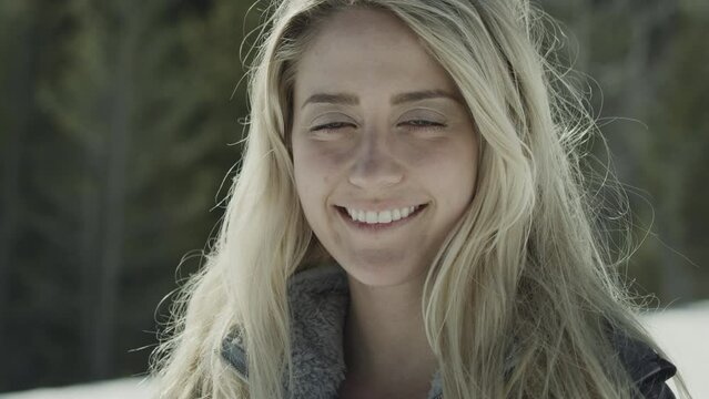 Close up portrait of smiling girl looking at camera in winter / Tibble Fork, Utah, United States