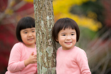 紅葉が綺麗な公園で自然を楽しむ小さな姉妹