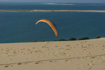 Single paraglider with parachute at the dune of Pilat on a sunny day, Arcachon, Nouvelle-Aquitaine,...