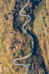 Aerial view with a curvy road, a sinuous trail in rural area in Romania