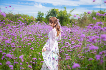 Obraz na płótnie Canvas woman wearing a long dress in a field of lavende flowers exudes a relaxed and freedom. Soft and select focus