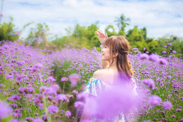 woman wearing a long dress in a field of lavende flowers exudes a relaxed and freedom. Soft and select focus