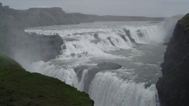 Scenic view of waterfall flowing over cliff / Gullfossi, Iceland