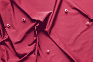 Viva Magenta color of the year 2023. Trendy top view on shiny disco balls on trendy textile...