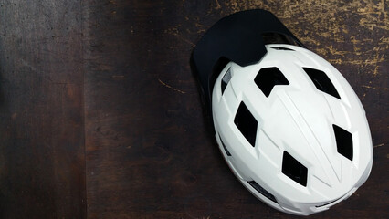 white helmet with black visor on a dark wooden table