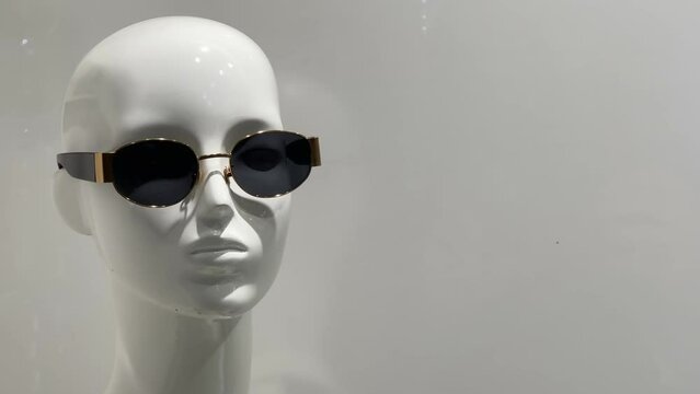 Portrait of a female mannequin in sunglasses standing in a shop window