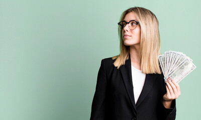 young pretty woman on profile view thinking, imagining or daydreaming. business and money concept