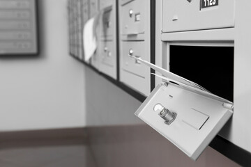 Open metal mailbox with envelopes indoors, closeup view