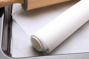 Parchment paper and rolling pin in baking pan, closeup