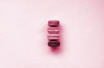 Dessert cake macaron or macaroon on trendy background top view. Flat lay composition. Image toned in Viva Magenta, color of the 2023 year