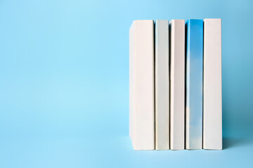 Collection of books on light blue background, space for text