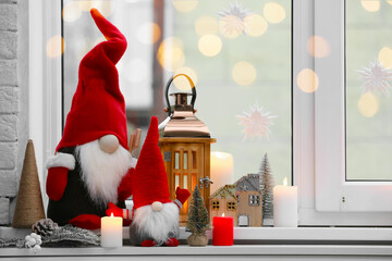Cute Christmas gnomes and other festive decorations on windowsill in room, space for text