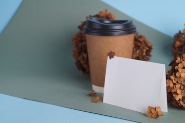 Dried hortensia flowers, blank card and paper cup on colorful background. Space for text