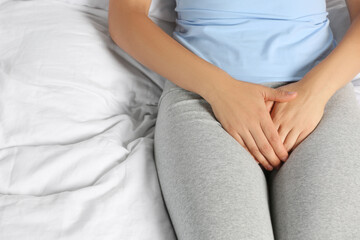 Fototapeta na wymiar Woman suffering from genital herpes on bed, closeup
