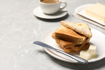Tasty toasts with butter served on grey marble table. Space for text