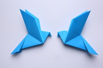 Beautiful blue origami birds on white background, flat lay.