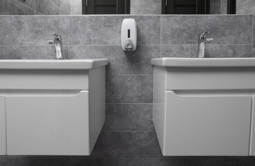 Fototapeta premium Public toilet interior with stylish white sinks and grey tiles