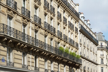 Fototapeta na wymiar Paris, France - The facade of typical Parisian buildings, done in the typical elegant Haussmann (or Haussmannian) 19th-century style.