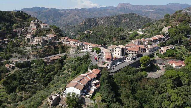 Fly backwards while panning left over mountain town