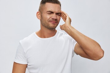 Man headache, migraine, high fever, in white T-shirt on white isolated background, copy space