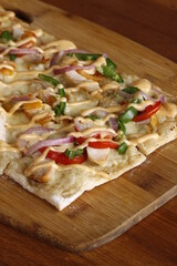 Square pizza with healthy ingredients on a wood board