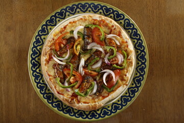 Anchovy pizza with onions, green and red bell peppers, cheese and tomato sauce
